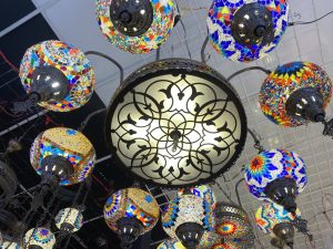 Colorful mosaic Turkish lamps hanging around an ornate central light.