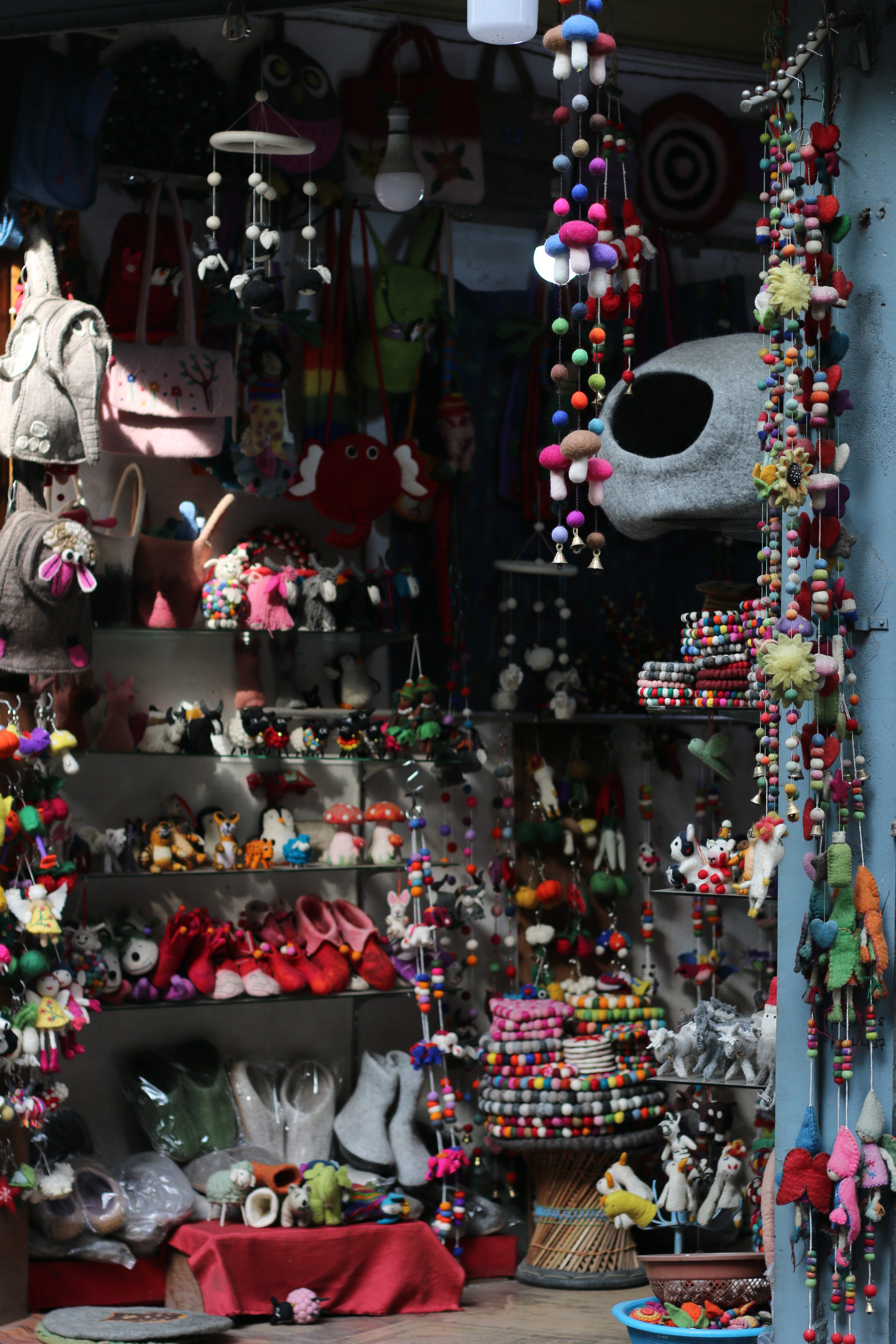 Part of a shop selling items made of felt. Many items hang from above on strings with small felt decorations on them.