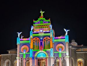 A church illuminated with vibrant colors during nighttime, showcasing architectural details and dynamic lighting in an urban setting.- Cartago, Costa Rica