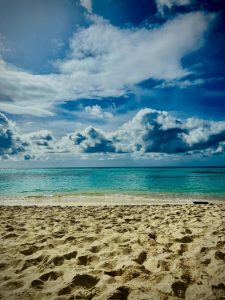 Playa con arena clara y mar azul bajo cielo con nubes - República Dominicana Isla Sanoa