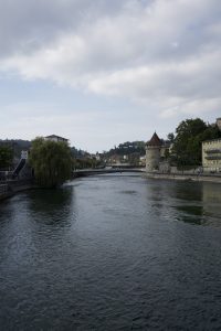 View of the Reuss River in Lucerne, Switzerland, with water, buildings, and bridges along the river.