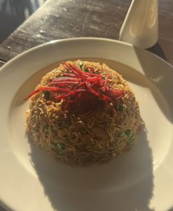 
A close-up shot of a serving of fried rice, elegantly presented in a dome shape on a white plate