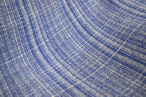 Close-up of a blue and white woven fabric texture with a diagonal pattern and soft focus.