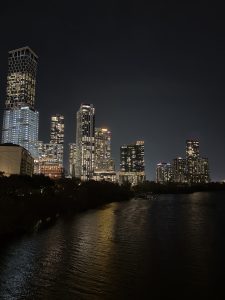 City in the night time. Dark background, night, light up skyscrapers, river.
