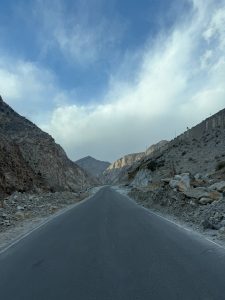 A serene hill station scene with a road running through the center, surrounded by  hills on both sides.

