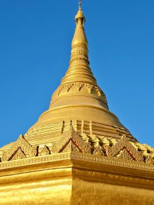Close-up of the golden dome and top structure of the pagoda against a deep blue sky at Global Vipassana Pagoda, Gorai Village, Mumbai.
