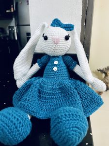 A crocheted stuffed rabbit with long white ears and a sweet expression.