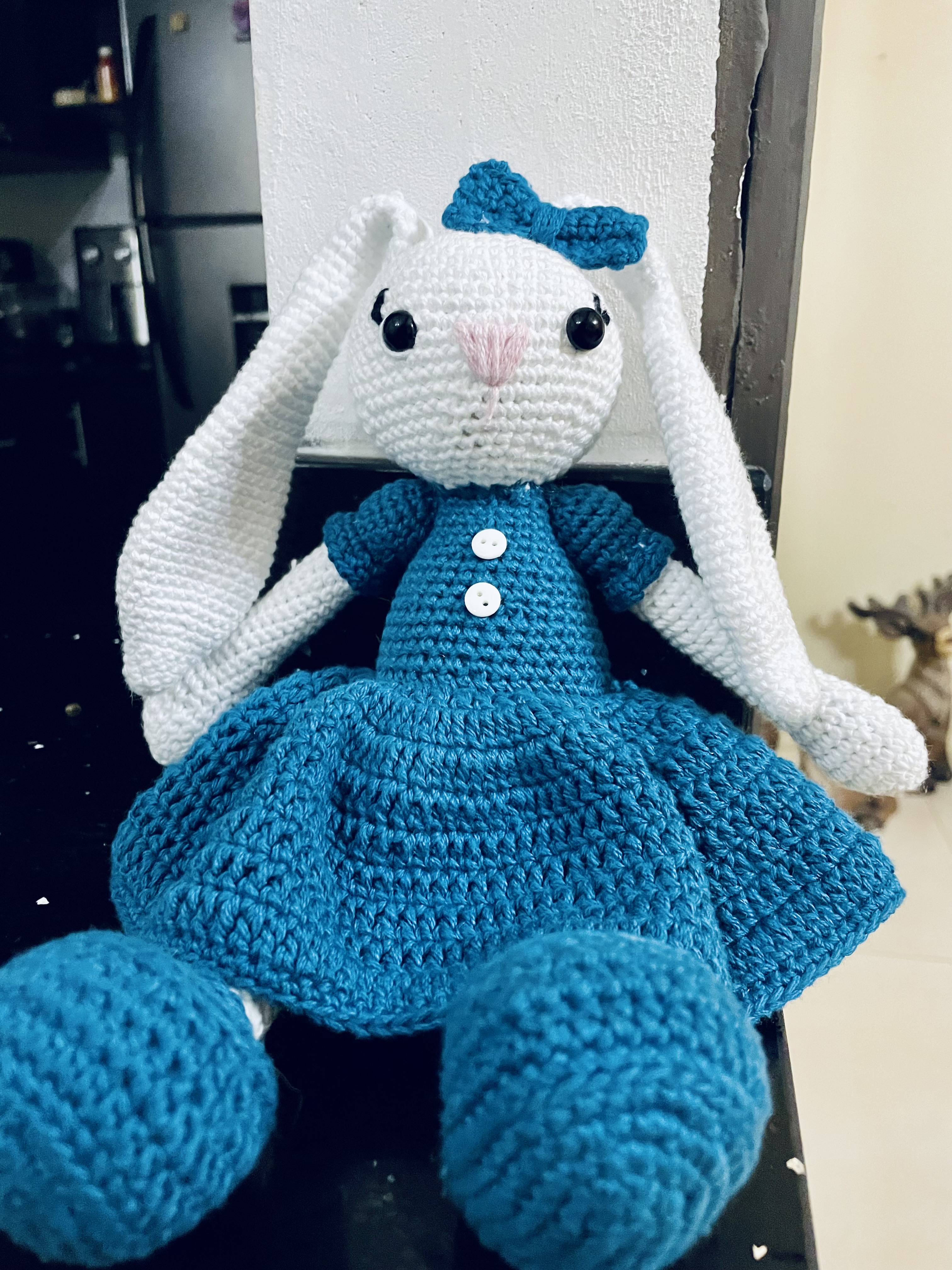 A crocheted stuffed rabbit with long white ears and a sweet expression.