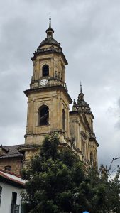 A historic church featuring detailed architecture and a clock tower, captured from a low angle against a cloudy sky.