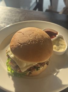 
A close-up view of a hamburger placed on a white plate. 