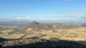 
A scenic view of rolling hills and valleys under a clear blue sky