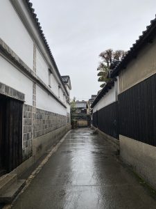 A traditional Japanese street on a rainy day, with historical buildings on the side.