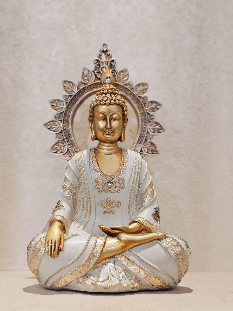 A calm Buddha statue in white and gold, placed indoors in the Global Vipassana Pagoda, Gorai Village, Mumbai. The peaceful expression and the soft background create a relaxing, spiritual mood.