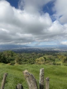 
A panoramic view of rolling green hills under a partly cloudy sky.