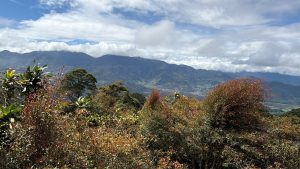 A panoramic view of a mountainous landscape under a partly cloudy sky.