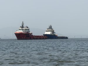 Two tugboat/supply ships in the water off the coast of India.