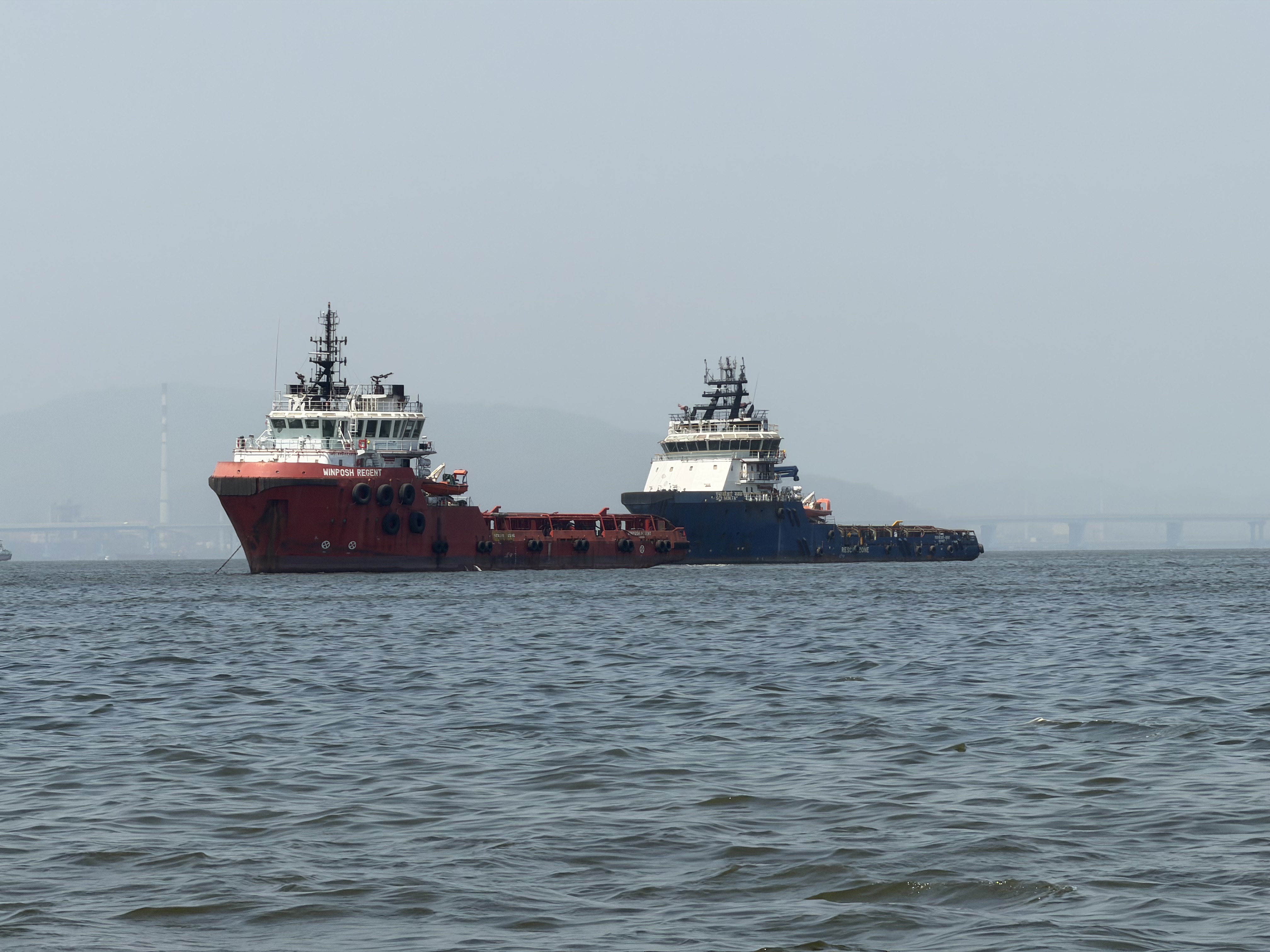 Two tugboat/supply ships in the water off the coast of India.