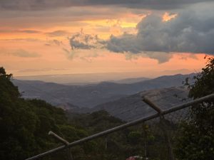 Mountain landscape with low clouds and orange tones on the horizon, conveying depth and calmness.