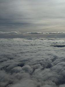Aerial view of clouds forming a soft blanket under a cloudy sky.