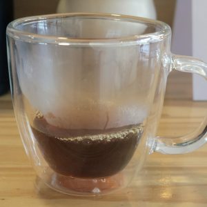 A glass cup filled with delicious black coffee.