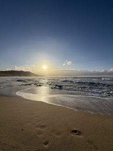 A serene sunset beach at Sardinia with soft sand and gentle waves.