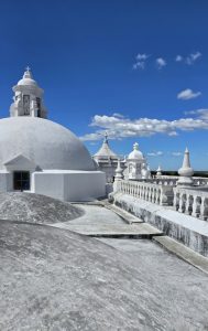 White domes and sleek structures stand under a clear blue sky, showcasing simple, elegant design.