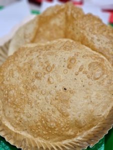 Golden, crispy Bhatura (poori) with a bubbly texture placed on a plate. A classic Indian bread captured in detail in Kurla, Mumbai.  