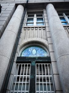 

A close-up view of a historic building facade featuring large stone columns and decorative architectural details.