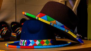 A medium, eye-level photograph of two felt fedora-style hats resting on a wooden surface.