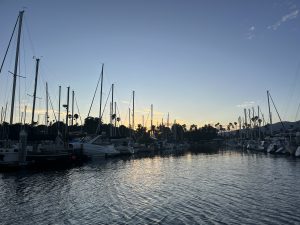 A handful of boats sitting on the horizon overlooking the beautiful sunset