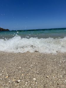 A close-up view of a sandy beach with gentle waves lapping at the shore