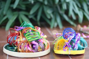 A colorful assortment of plastic bangles arranged in two baskets. 