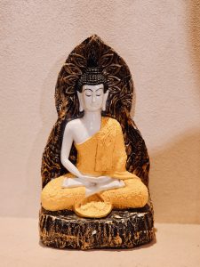 A decorative Buddha statue with a black and golden backrest in the Global Vipassana Pagoda, Gorai Village, Mumbai. The detailed design and bright colors make it visually rich and eye-catching.
