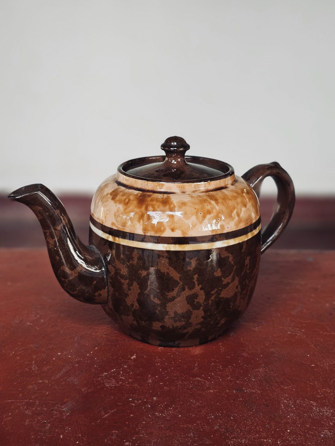 A vintage brown ceramic teapot with artistic textures and earthy shades creates a warm, traditional look. The balanced framing and rich details make the image visually appealing. Captured at Mangode, Puthunagaram, Palakkad.