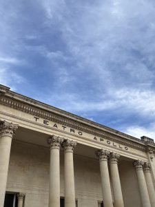 Teatro Apollo facade with Corinthian columns under a blue sky.
