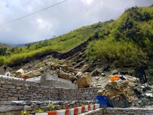 Terraced stone walls lead up a slope covered in lush greenery.