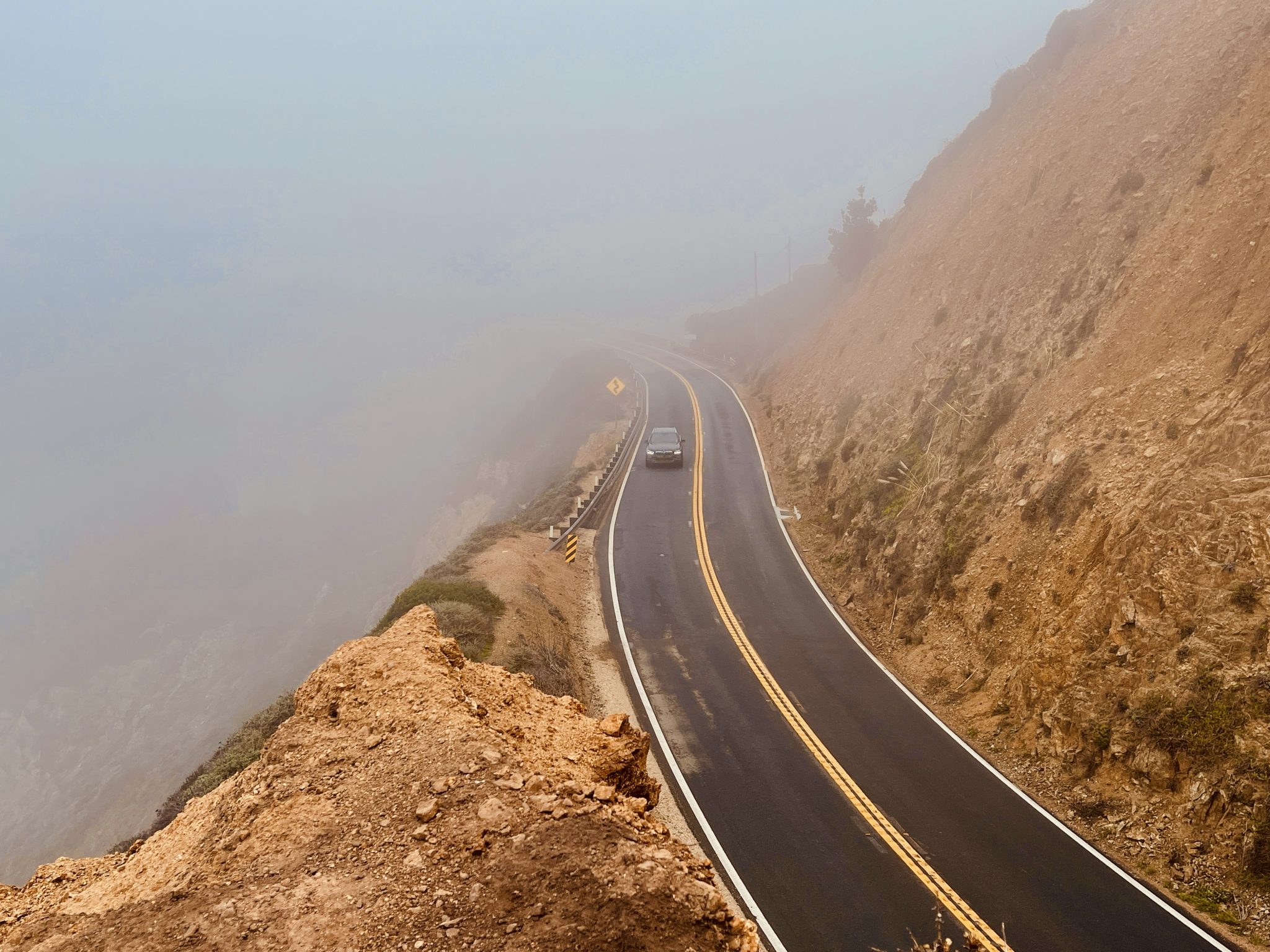 A cliffside mountain highway disappearing into low cloud — photo by Sakin Shrestha, WordPress Photo Directory (CC0)