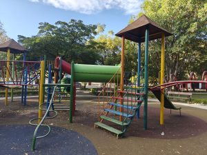 A playground filled with colorful structures invites play and fun, featuring slides, tunnels, and themed areas. Children enjoy exploring while adults relax nearby, creating a cheerful and family-friendly atmosphere.