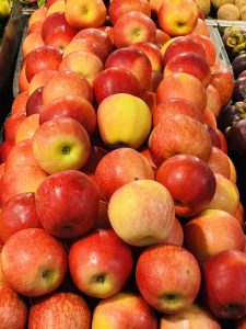 A vibrant display of red and yellow apples stacked in neat rows at a market