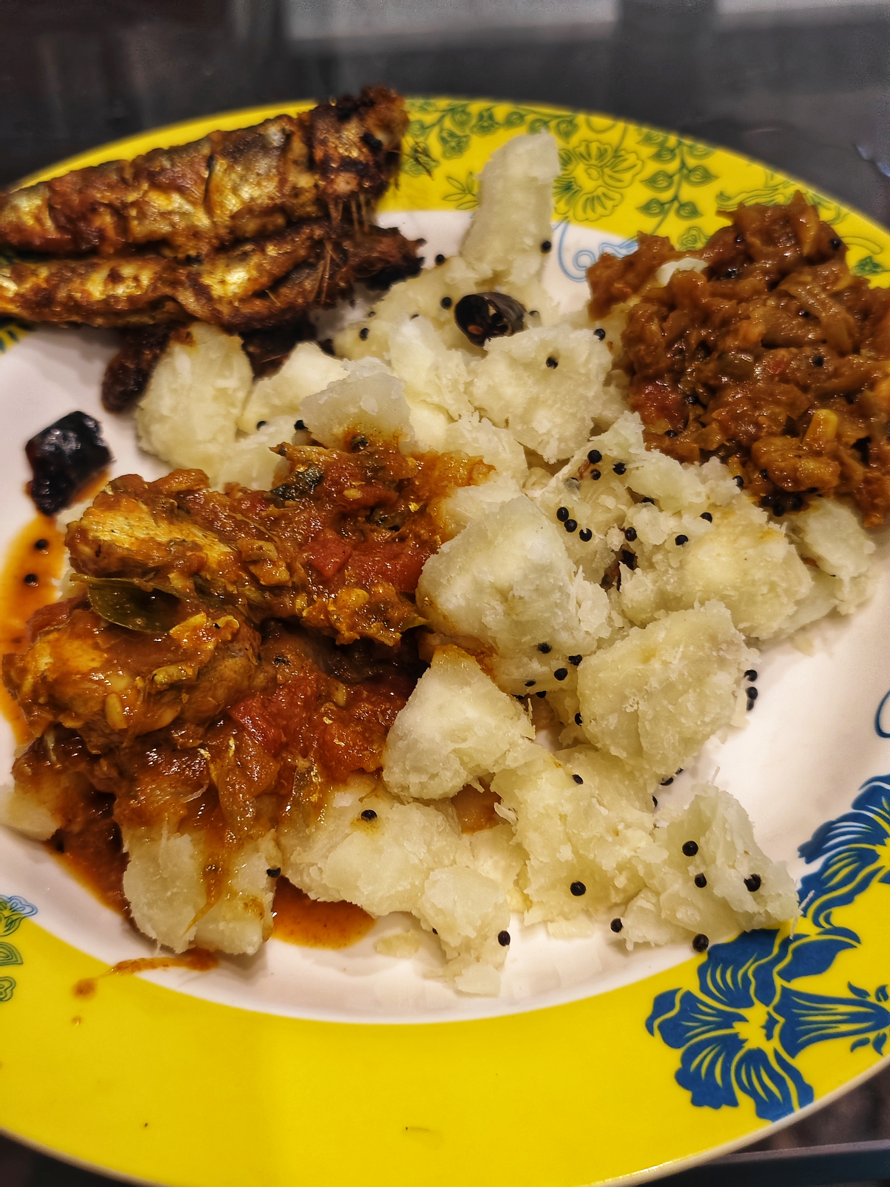 A colorful plate of boiled cassava (kappa) topped with tangy sauce and pieces of meat.