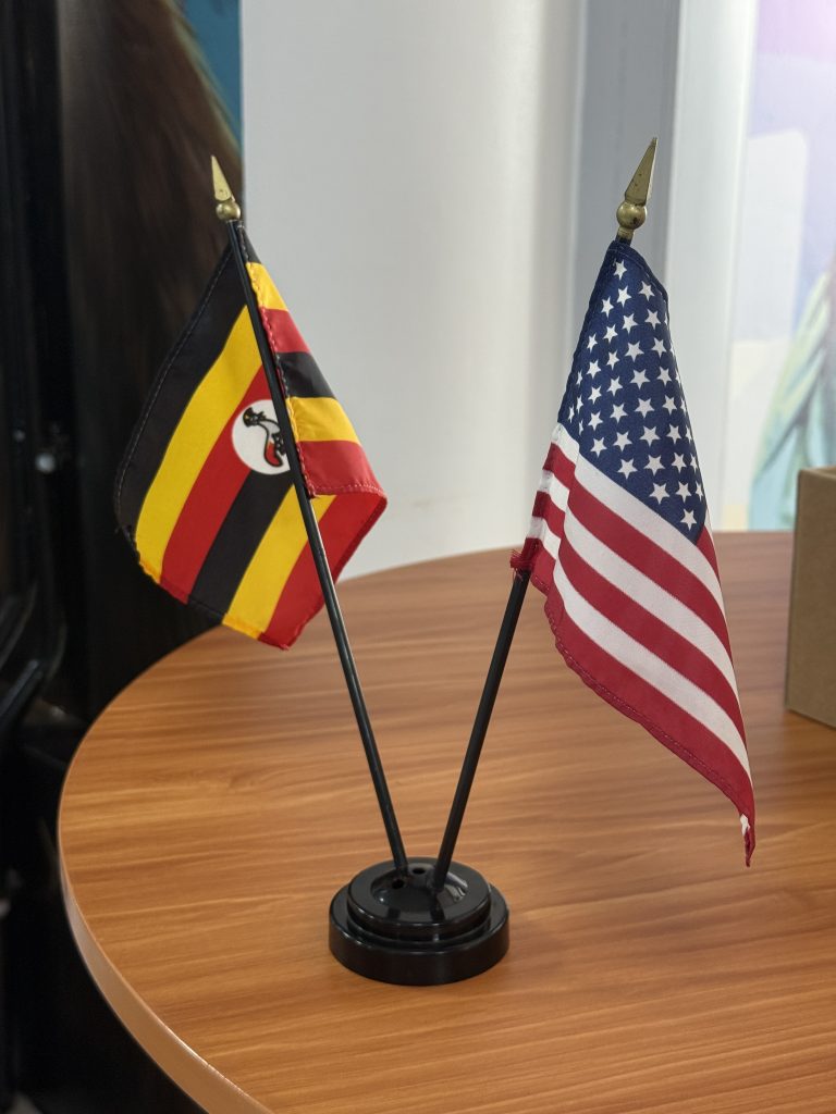 The Uganda and American flags on a table. They’re quite small.