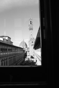 Black and white view of Florence, Italy's Duomo through a window.