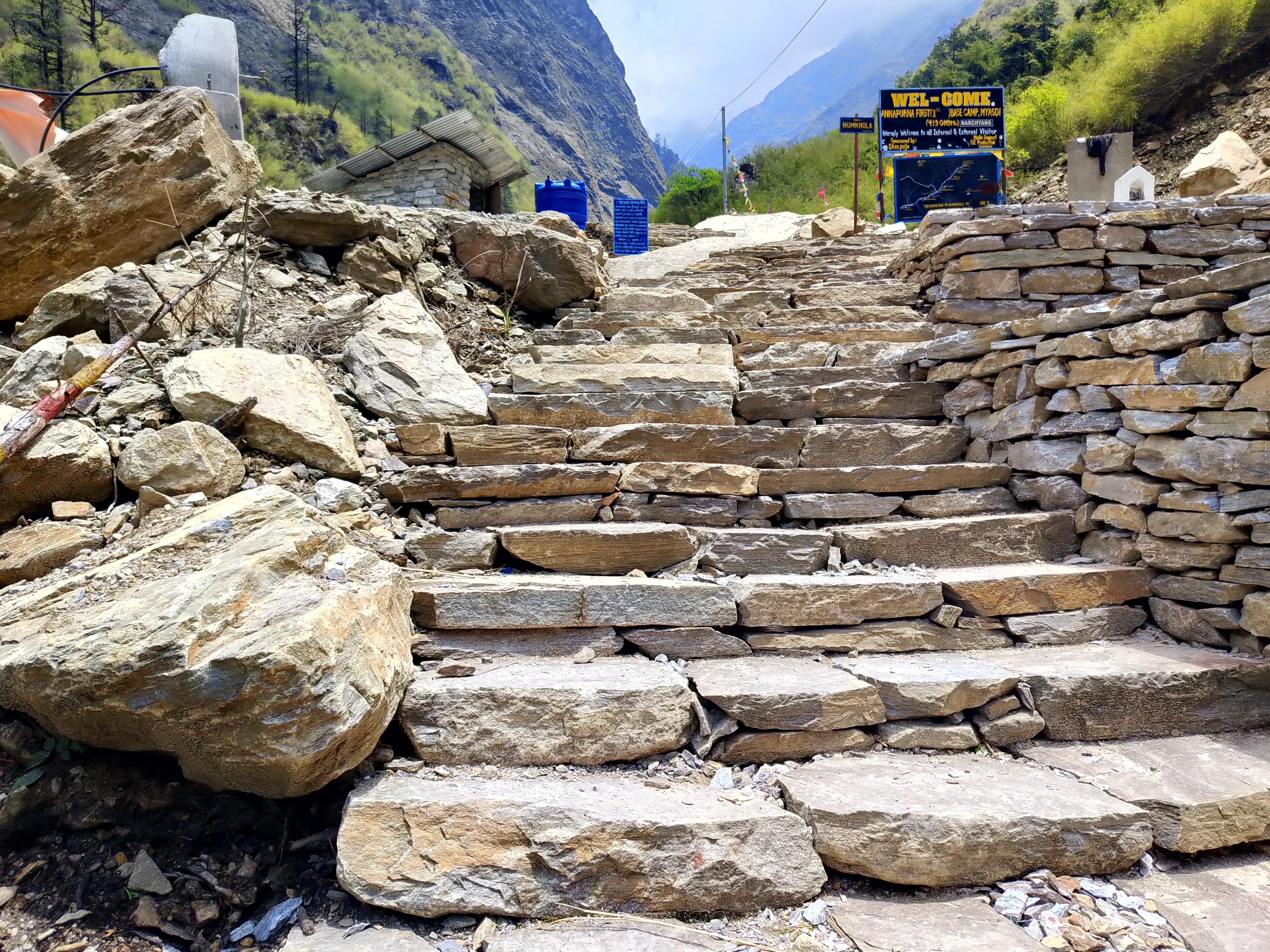 Rugged stone steps lead upward, flanked by rocky terrain and retaining walls.