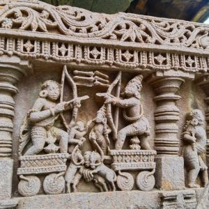 Ancient stone carving depicting two warriors with bows and arrows, surrounded by intricate patterns and figures, exuding a sense of historical grandeur
