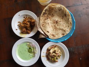  A dining table set with three distinct plates of food, showcasing a variety of dishes for a shared meal.