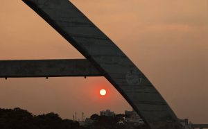 Sunset view with a large concrete arch in the foreground.