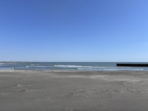 
A serene beach scene featuring gentle waves lapping the shore under a clear blue sky.