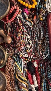 Close-up of necklaces and bracelets made from pebbles of different shapes, sizes, and colors.
