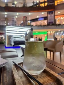 Coconut Cloud Matcha. A matcha and coconut based drink on the backdrop of a mall. 
