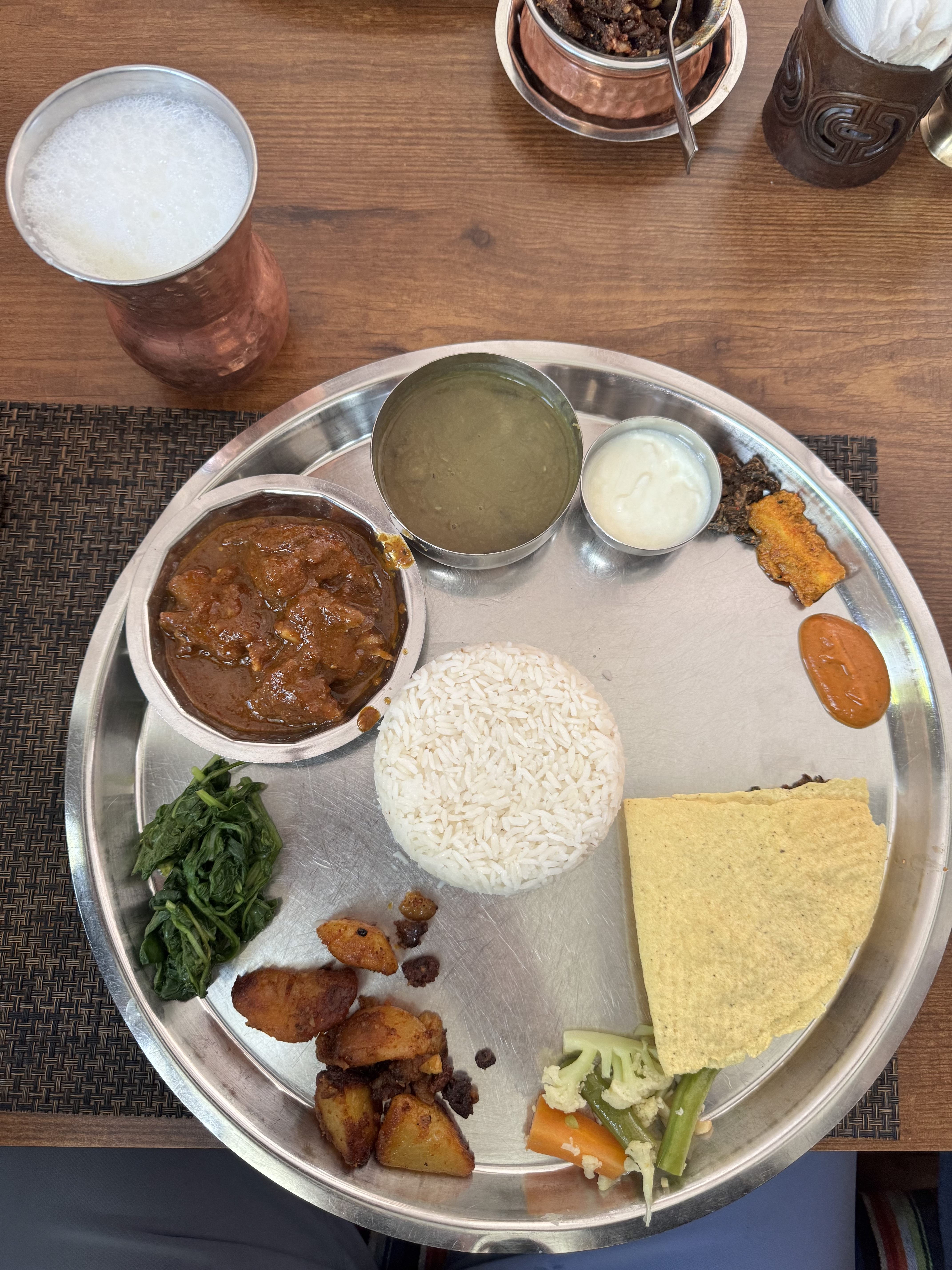 Nepali Thakali Dal bhat set. Traditional Nepali staple meal. Contains rice, bean lentils, mutton curry, vegetables, pickles and Mohi (butter-milk) on the side.